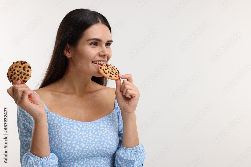Young woman with chocolate chip cookies on white background, space for text Young woman with chocolate chip cookies on white background, space for text