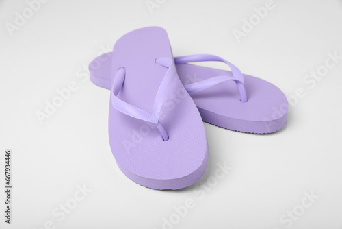 Stylish violet flip flops on white background