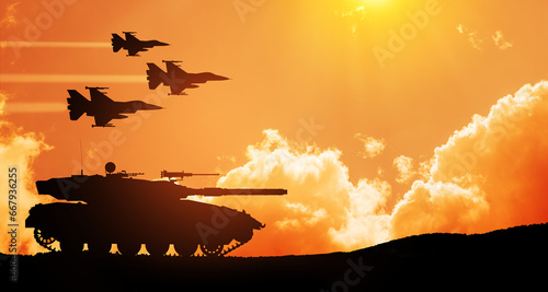 Silhouettes of army tank and fight planes on background of sunset.