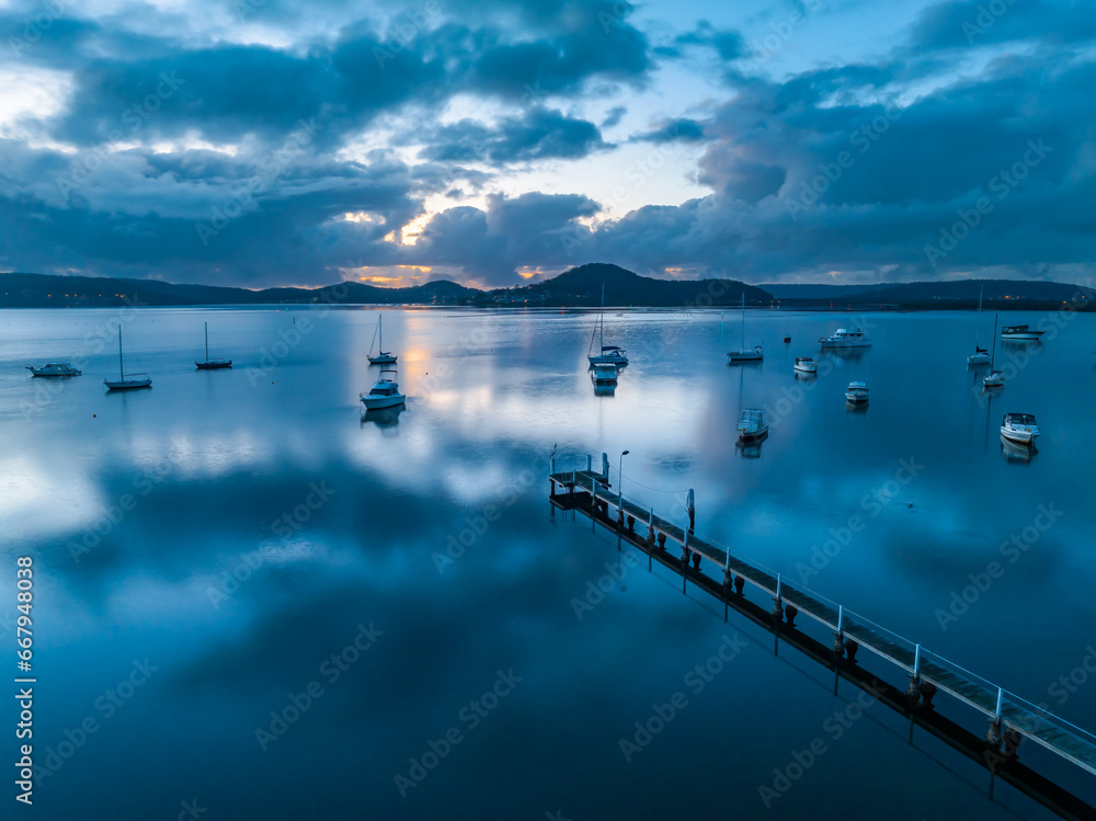 Sunrise blues over the bay with boats and clouds