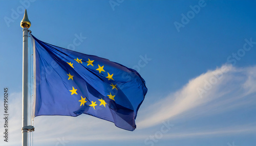 Close up view of an EURO flag waving on a flagpole, with blue sky background and copy space