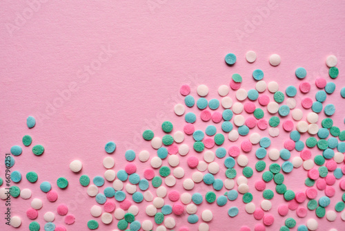 Multi-colored confectionery topping on a pink. © Marevgenna