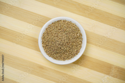 Top view of carom seeds on wooden background, ajwain photo