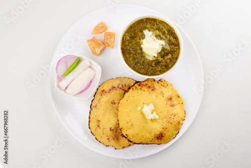 Top view of sarson ka saag with makki ki roti in plate on white background photo