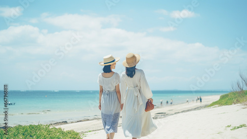 海に向かって歩く若い女性の後姿