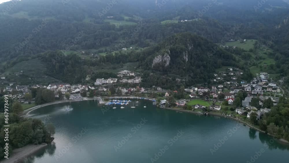 A breathtaking aerial view of Walensee and Weesen showcasing the navy blue waters, residential area, and the Swiss Alps in the background A breathtaking aerial view of Walensee and Weesen showcasing the navy blue waters, residential area, and the Swiss Alps in the background