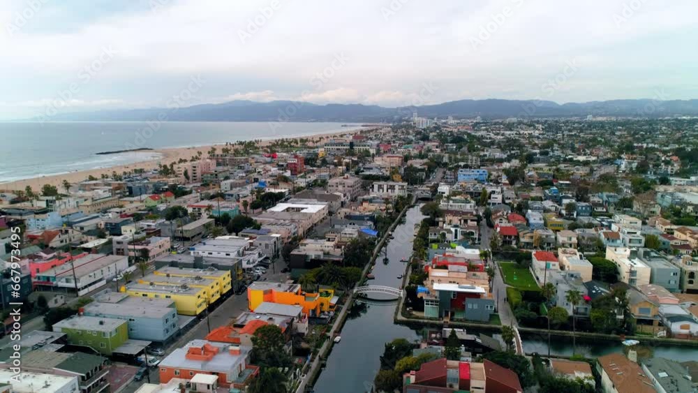 Aerial Backward Shot Of Canal Amidst Houses In Suburb Near Sea Against Cloudy Sky - Los Angeles, California Aerial Backward Shot Of Canal Amidst Houses In Suburb Near Sea Against Cloudy Sky - Los Angeles, California