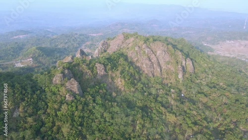 Aerial view of beautiful landscape of towering rock mountains with dense of forest. Prehistoric volcano of Nglanggeran, Yogyakarta, Indonesia - 4K drone shot photo