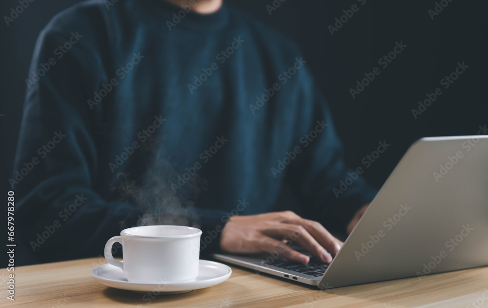 working on a laptop was a coffee cup and steam smoke rising up working on a laptop was a coffee cup and steam smoke rising up