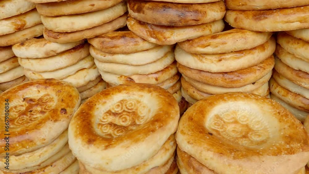 Bread from tandoor in Central Asia. Traditional Uzbek the pellets. Tandoor baked flat bread, flat cake or bread cake. National asian meal and food. Bread from tandoor in Central Asia. Traditional Uzbek the pellets. Tandoor baked flat bread, flat cake or bread cake. National asian meal and food.