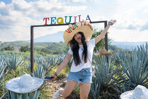 La joven está feliz en el campo de agaves del pueblo de Tequila Jalisco México. photo