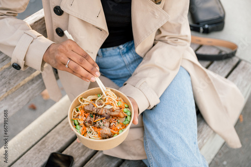 Crop woman with bowl of asian food