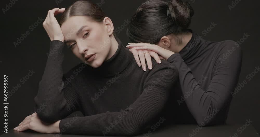 Two young elegant women with good makeup on a black background Two young elegant women with good makeup on a black background