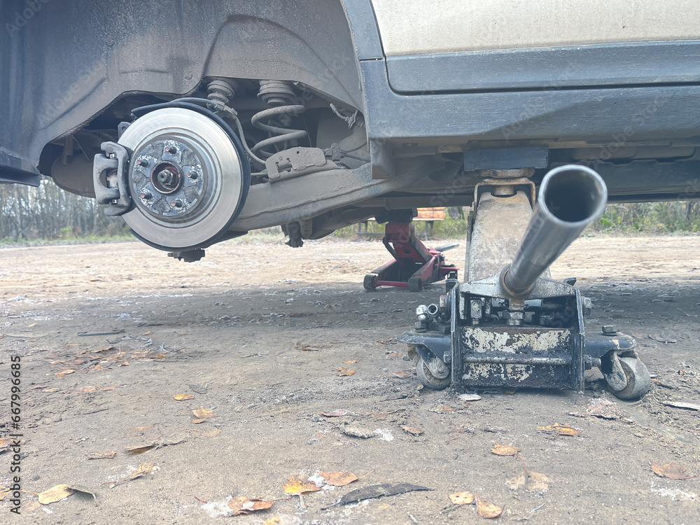 a car without wheels on jacks when replacing rubber, changing seasons, it's time to change summer tires to winter tires