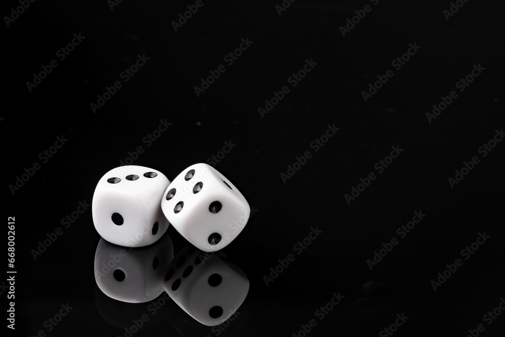 White dice on black background studio shot White dice on black background studio shot
