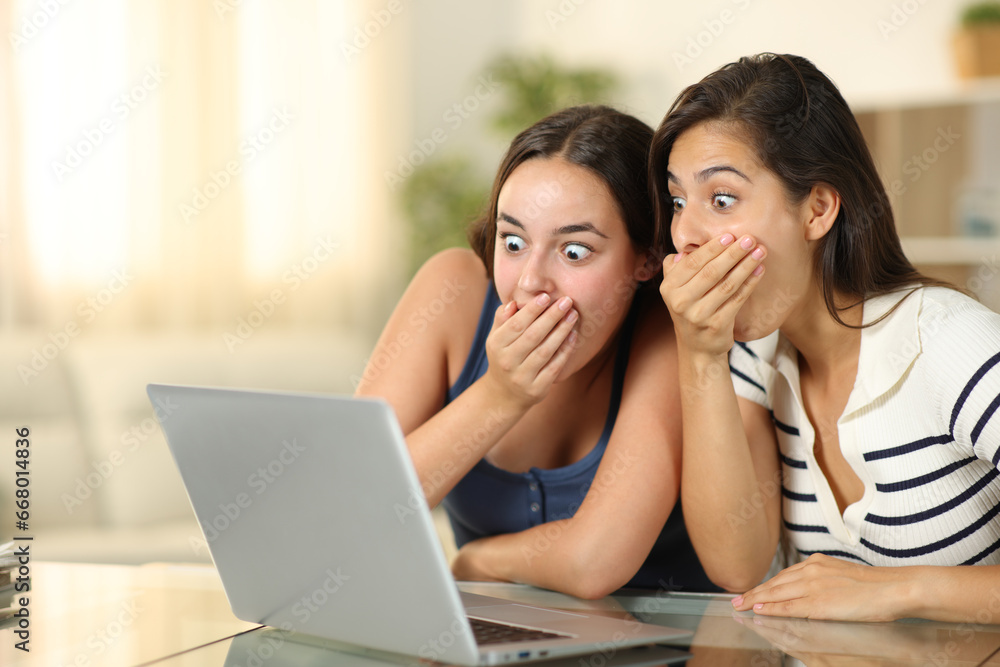Shocked women checking media on laptop