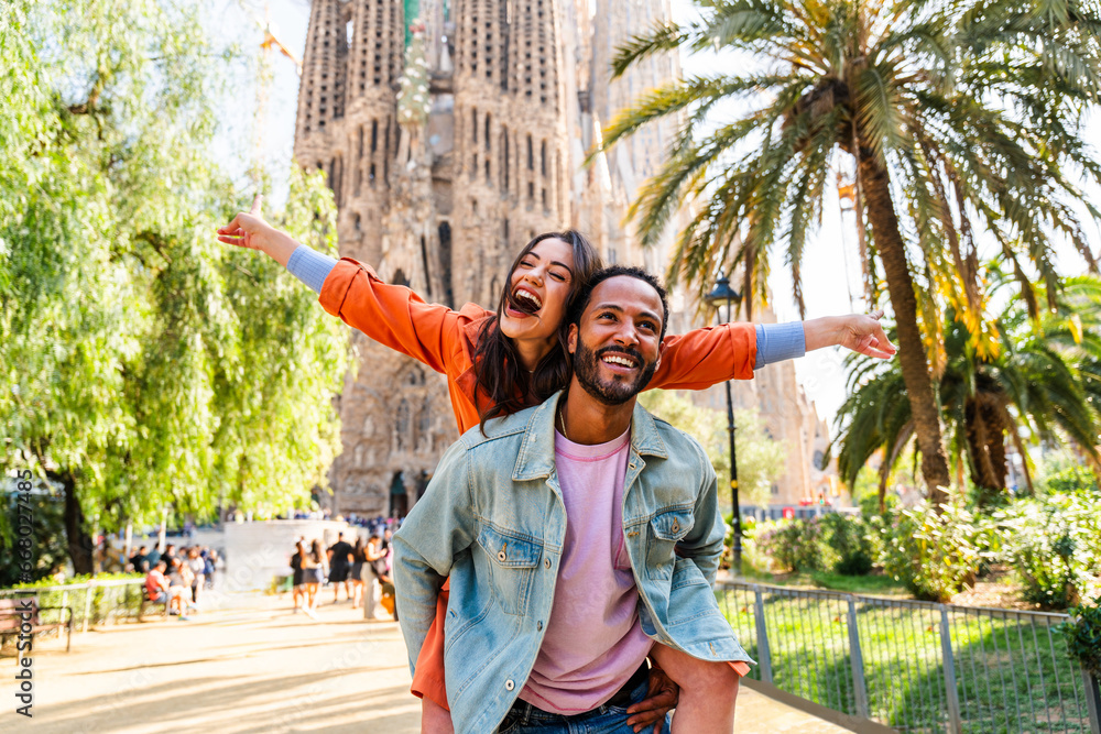 Obraz na płótnie Multiracial beautiful happy couple of lovers dating at Sagrada Familia, Barcelona - Multiethnic tourists travelling in Europe and visiting a city in Spain, concepts about tourism and people lifestyle w salonie
