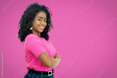 Laughing mexican young adult woman on pink background