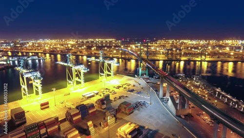 Aerial Time Lapse Shot Of Vehicles Moving On Bridge Over River In Illuminated City Against Sky At Night - San Pedro, California photo
