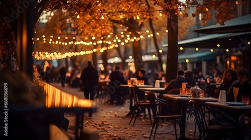 People have dinner in a street restaurant. Evening cafe with a warm garlands.