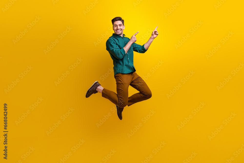Photo of satisfied nice man dressed stylish clothes presenting empty space benefit news poster isolated on yellow color background