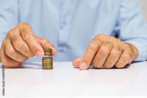 A man's hand moves stacks of coins across the table. Creative concept of stock market movement.