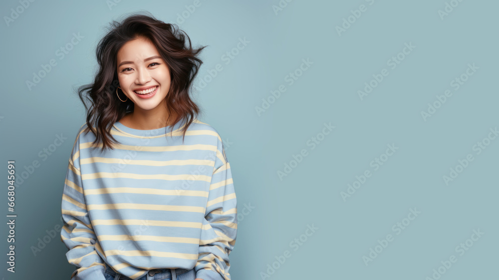 Obraz premium An Asian woman wearing striped sweatshirt isolated on pastel background
