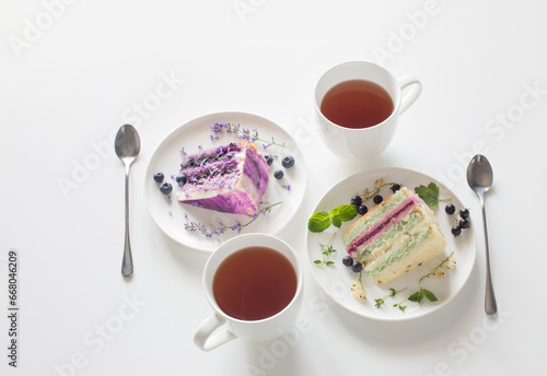 berry cheesecakes and two cups of tea on  white table