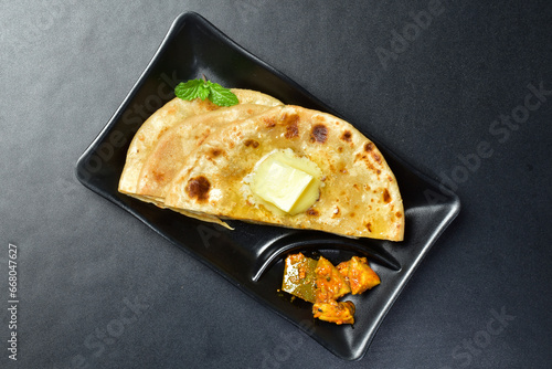 Top view of butter aloo paratha with aam ka aachar in plate, healthy indian breakfast photo