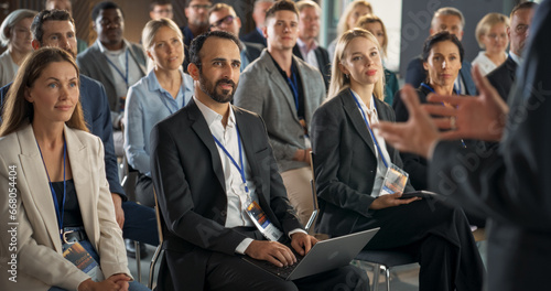 Backview Of Environment Specialist Gesturing And Presenting To Audience of Diverse Business Leaders. Male And Female Attendees Listening To Inspirational Speech On International Economic Forum. photo