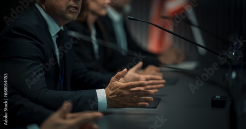 Close Up On Hands of Caucasian Male Organization Representative Speaking at Economic Conference. Head Of USA Delegation Delivering Speech at International Political Summit. Diverse Delegates Listening