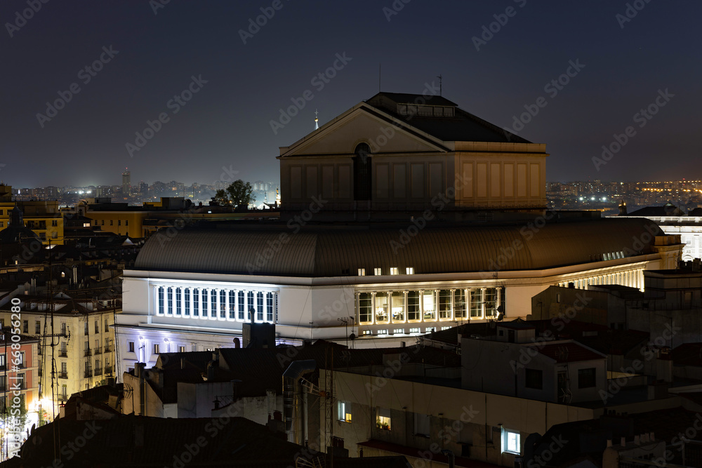 Fototapeta premium Aerial view of the Teatro Real (Royal Theatre) in Madrid at night, surrounded by illuminated buildings