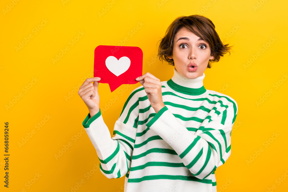 Photo of cute impressed girl dressed striped sweater big eye showing positive feedback card isolated yellow color background Photo of cute impressed girl dressed striped sweater big eye showing positive feedback card isolated yellow color background