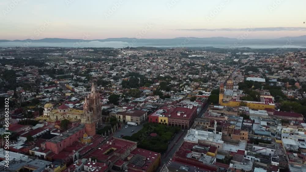 Aerial view over the colorful city of San Miguel De Allende, Guanajuato State in Mexico with view of the neo-Gothic church Parroquia de San Miguel Arcángel and the colorful cityscape at golden hour Aerial view over the colorful city of San Miguel De Allende, Guanajuato State in Mexico with view of the neo-Gothic church Parroquia de San Miguel Arcángel and the colorful cityscape at golden hour