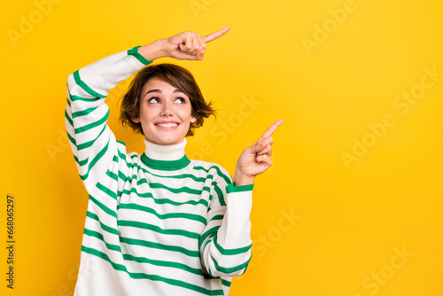 Photo of funny cute lady indicating fingers empty copy space promotion placard wear pullover isolated yellow color background