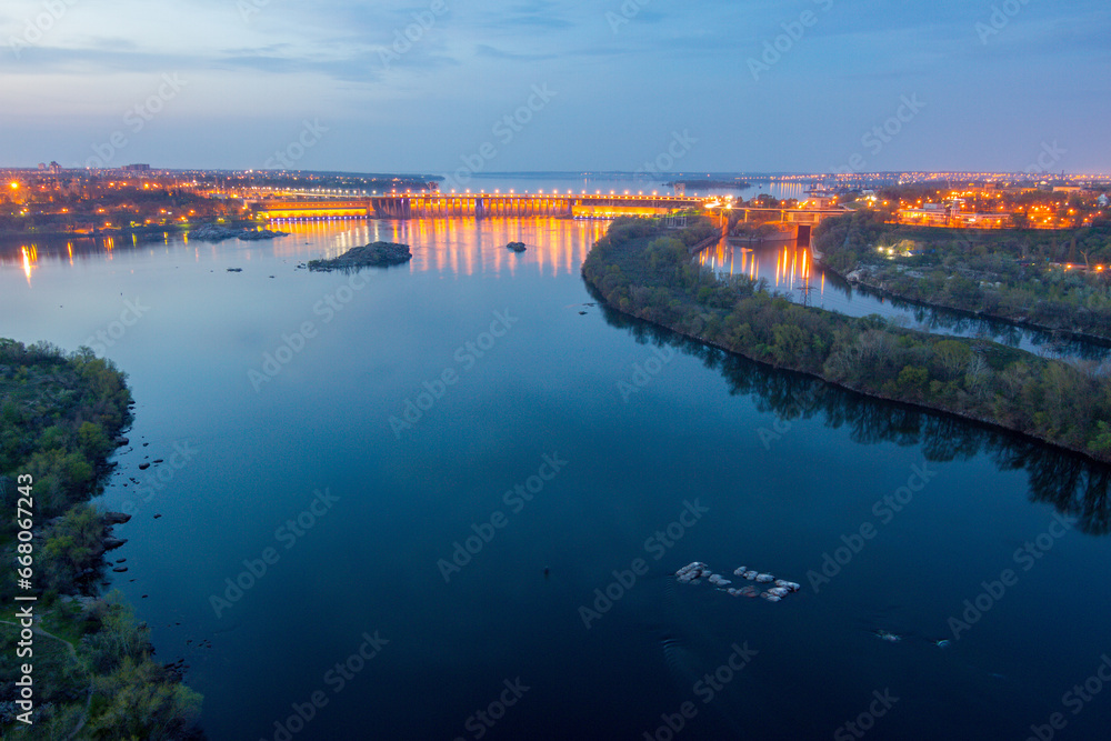 Evening view of Dnieper river with illuminated Dneproges hydroelectric dam from the height of 100 m, Zaporizhzhia, Ukraine