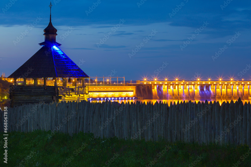 Φωτογραφία Evening view of wooden tower on Zaporozhian Sich cossacks fortress and illuminat