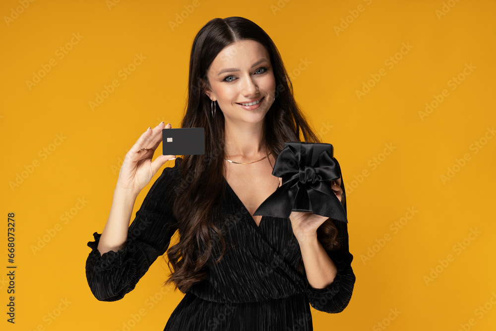 A girl with a credit card on a yellow background. A girl with a credit card on a yellow background.
