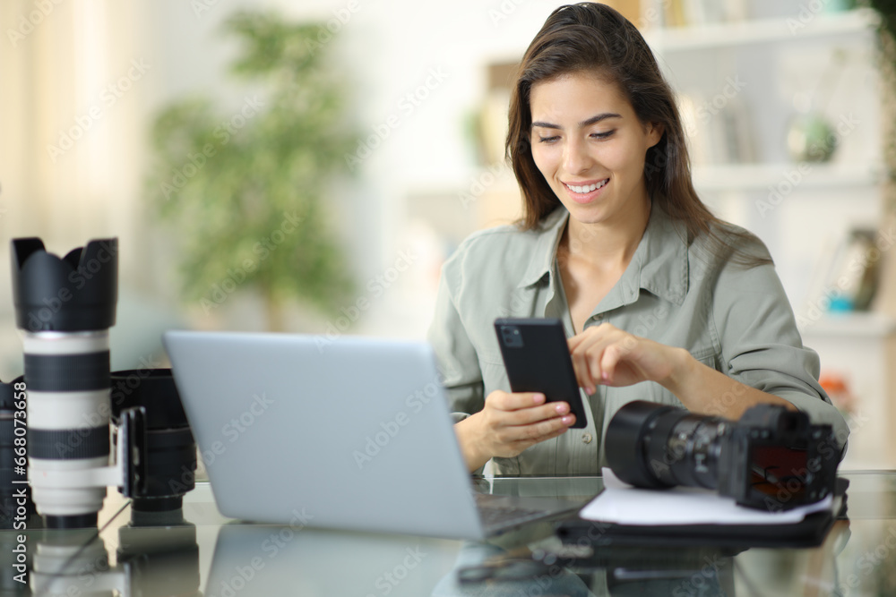 Happy photographer checking phone at home Happy photographer checking phone at home