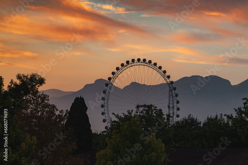 Big Ferris wheel in the amusement park at sunset in Konyaalti Antalya