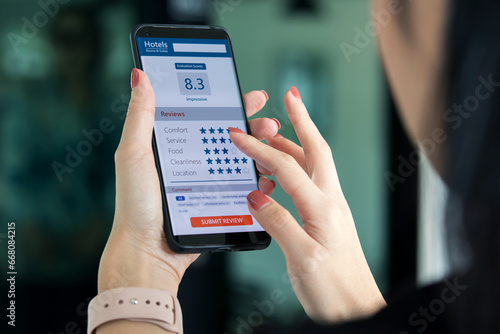 Evaluating customer satisfaction with hotel services. female customer using smartphones gave a very good satisfaction rating and offered advice on service provided by hotel's online Application