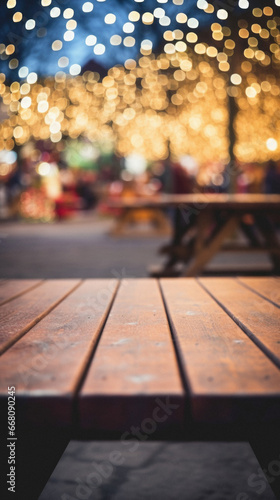 Empty wooden table and blurred background of Christmas market with bokeh.