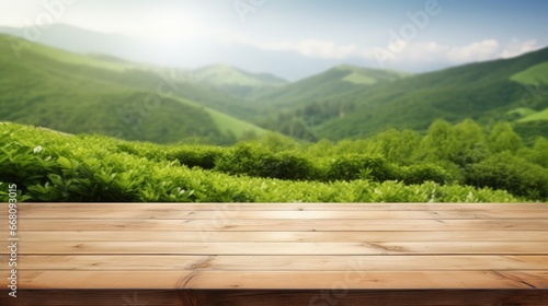 Wooden table top with blurred green tea mountain and grass field representing a fresh and relaxing concept for product display or design layout with available copy space © vxnaghiyev