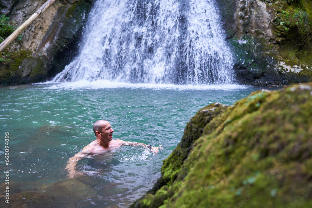 Strong man bathing in a waterfall Strong man bathing in a waterfall
