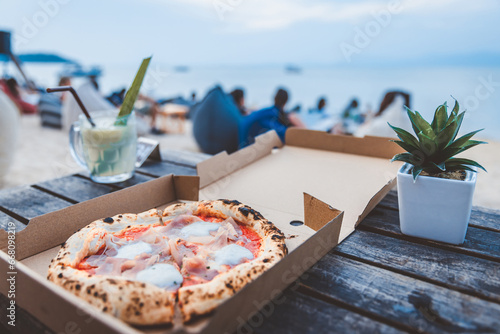 Fototapeta Naklejka Na Ścianę i Meble -  Italian Pizza Margherita with parma ham and mozzarella cheese in box at beach club Thailand