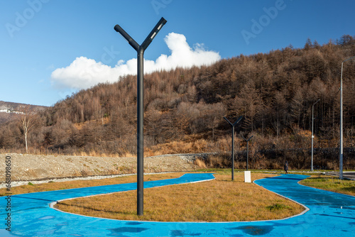 Pedestrian paths and lanterns in the park. Autumn season. A park in a valley among the hills. Ethnopark Dyukcha, Magadan, Magadan region, Russia. Improvement in the Russian Far East. photo