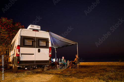 Family is enjoying the camper van under the stars.