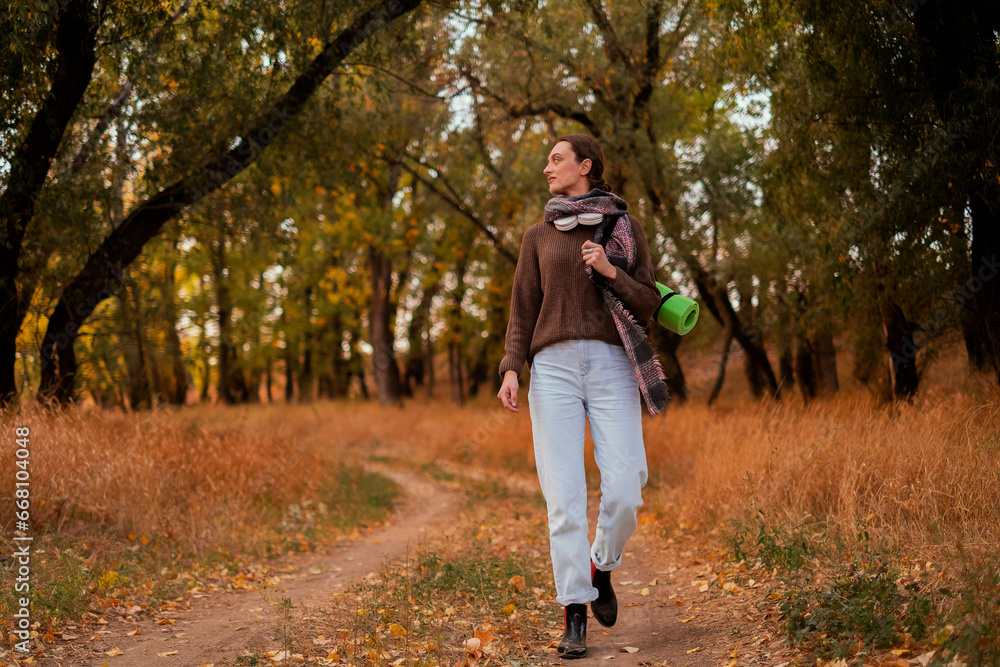 woman walking in the forest, female traveler walking through the forest on a sunny autumn day, young Caucasian woman hiking, girl with a tourist backpack walking in the forest woman walking in the forest, female traveler walking through the forest on a sunny autumn day, young Caucasian woman hiking, girl with a tourist backpack walking in the forest