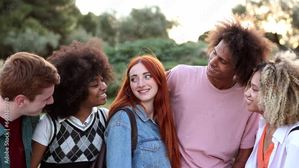 group of multiracial young people chatting outdoors at sunset group of multiracial young people chatting outdoors at sunset