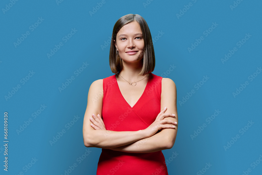 Portrait of young confident woman in red on blue studio background Portrait of young confident woman in red on blue studio background